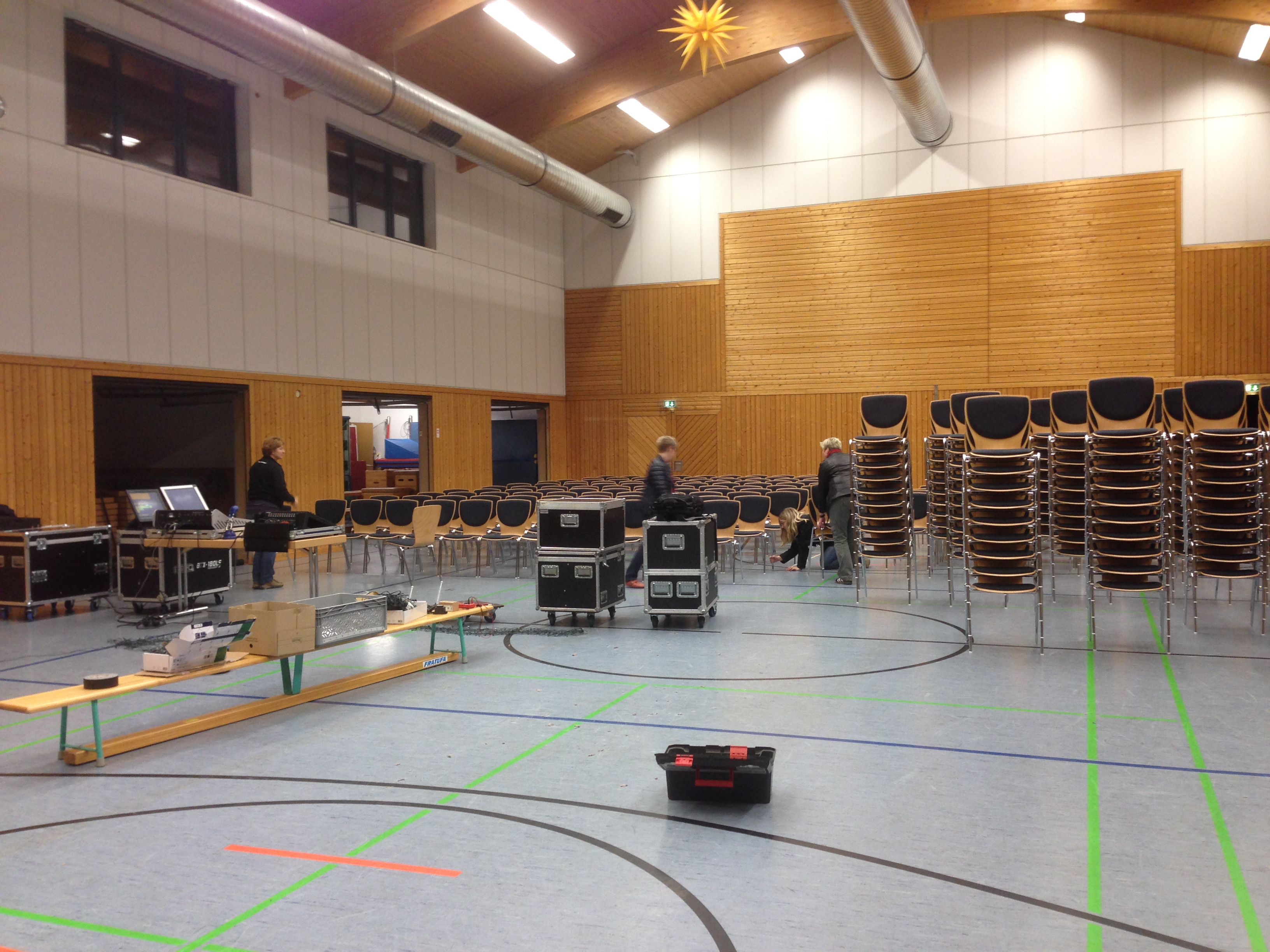 Noch befindet sich die Halle im Chaos. Die Ton- und Lichttechnik ist schon am werkeln und einige Stühle sind aufgestellt.